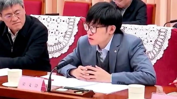 Two men sit in a conference hall in China