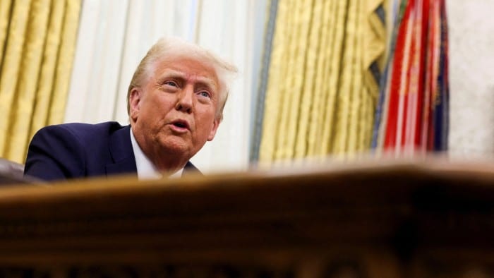 Donald Trump at his desk in the Oval Office