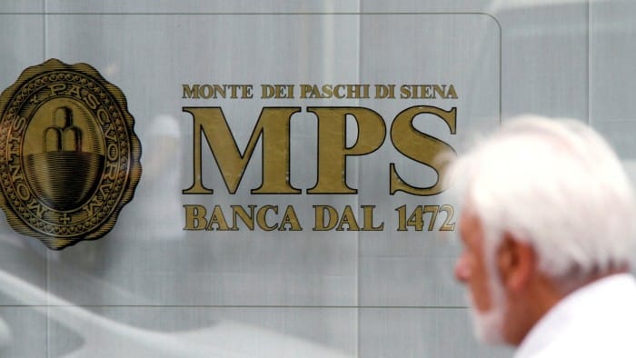 A man walks past a Monte dei Paschi di Siena bank in downtown Milan.