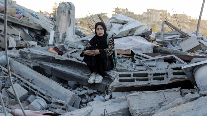 A Palestinian woman sits on debris in Jabalia refugee camp, northern Gaza