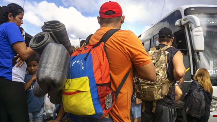 Migrants board a bus, traveling to Nicaragua, near the Las Tablillas crossing in Los Chiles, Costa Rica