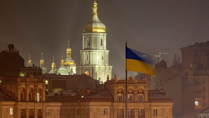 A Ukraine flag flies in front of Kyiv’s skyline