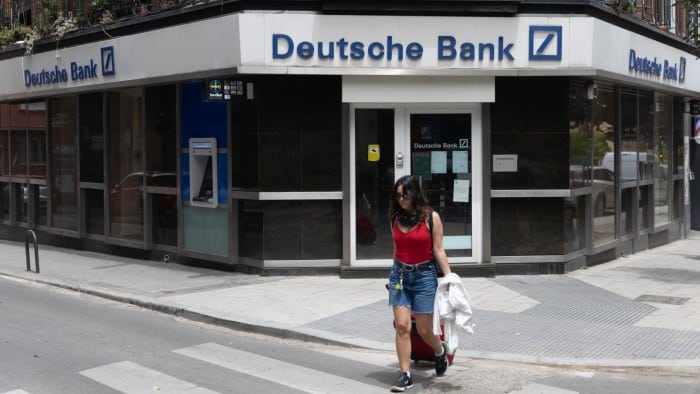 A woman walks past a Deutsche Bank branches in Madrid