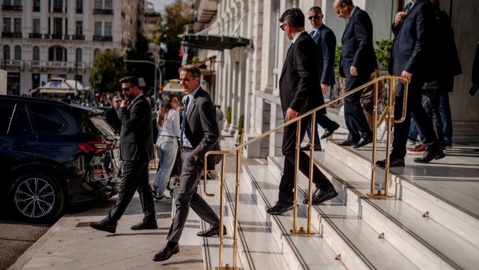 Men in suits walk down stairs