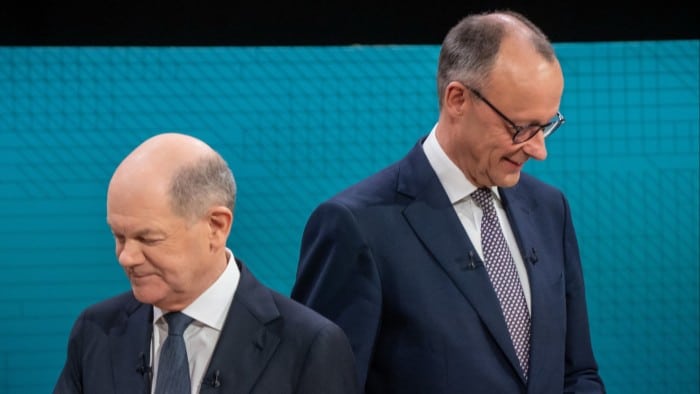 German Chancellor Olaf Scholz (L), main candidate for the Social Democratic Party (SPD), and Friedrich Merz, main candidate and chairman of the Christian Democratic Union (CDU) take up their positions prior to the TV debate j