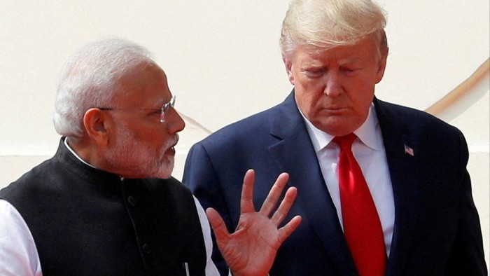 Narendra Modi speaks while walking alongside Donald Trump as they arrive for a 2020 news conference in India