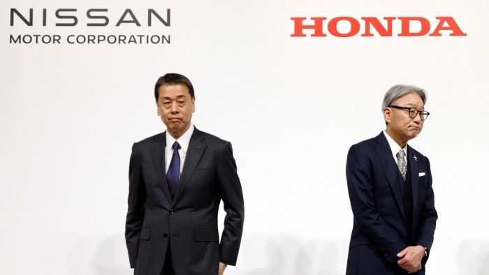 Makoto Uchida and Toshihiro Mibe stand at the end of a joint press conference in Tokyo, with the Nissan and Honda logos visible behind them