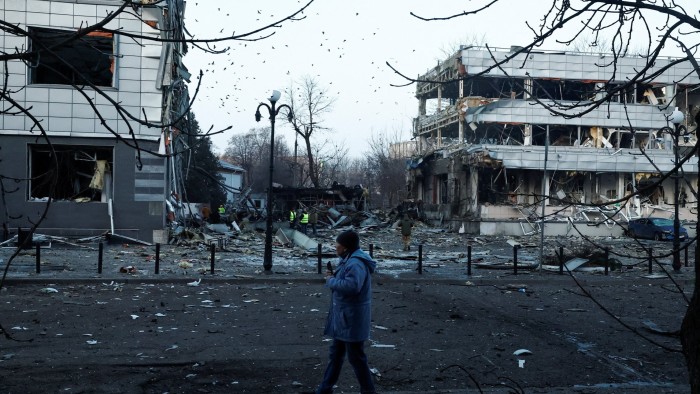 A man walks past buildings heavily damaged by a Russian missile strike in Kyiv