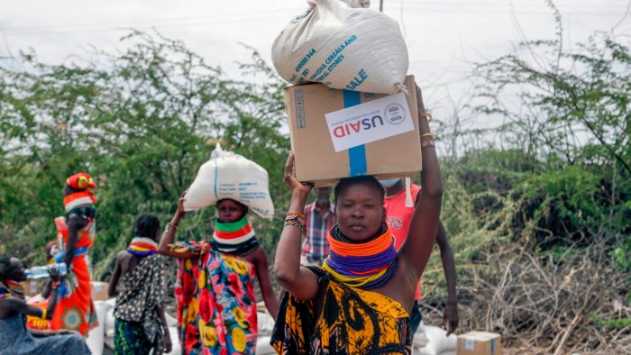 People carry boxes and sacks of food distributed by the United States Agency for International Development in northern Kenya