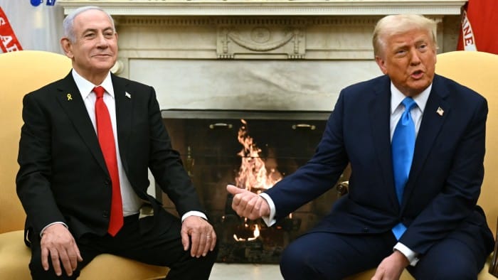 Donald Trump sitting with Benjamin Netanyahu in front of a fireplace at the Oval Office