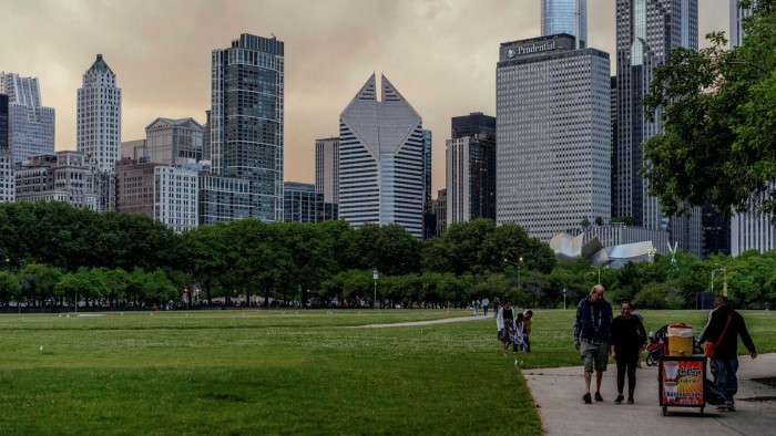 Tourists walk through a park in Chicago, Illinois