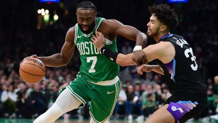 Boston Celtics guard Jaylen Brown, left, controls the ball while Utah Jazz guard Johnny Juzang defends during a game at TD Garden arena in Boston