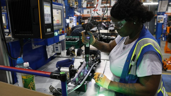 An employee installs lights in an instrument panel at the Dakkota Integrated Systems manufacturing facility in Detroit