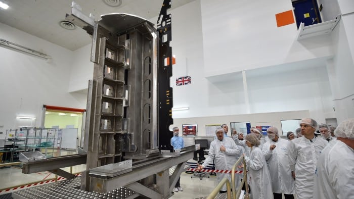 Technicians and media personnel observe a part of the Eutelsat Quantum satellite