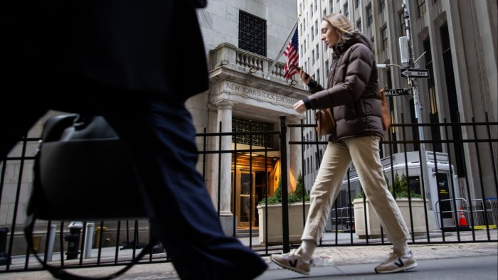 A pedestrian walks past the New York Stock Exchange