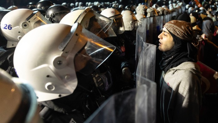 A protester faces a line of riot police during a demonstration in Istanbul on Monday