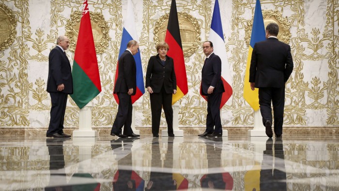 Alexander Lukashenko, Vladimir Putin, Angela Merkel, Francois Hollande and Petro Poroshenko walk past national flags at the presidential residence in Minsk