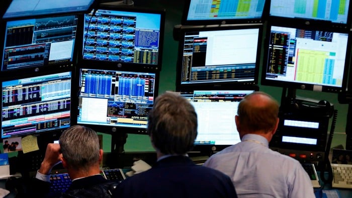 Traders work at Bloomberg terminals on the floor of the New York Stock Exchange