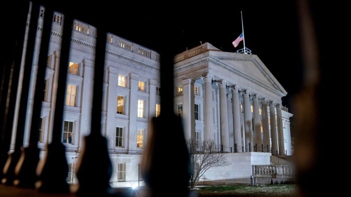 The front facade of the US Treasury building is pictured lit up at night