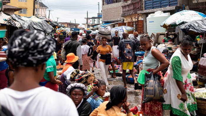 A vendor carries a bag on her head full of fabric in Freetown, Sierra Leone