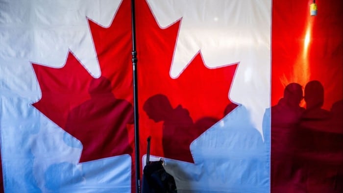 Supporters’ shadows are seen behind a Canadian flag during a campaign rally in Oakville in Ontario