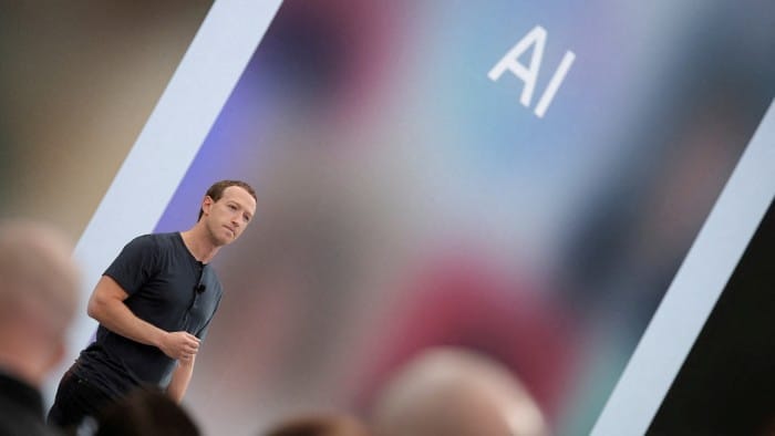 Mark Zuckerberg delivers a speech, as the letters AI for artificial intelligence appear on a screen