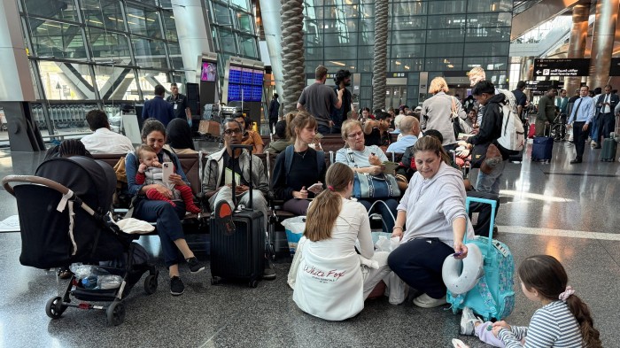 People sit at Hamad international airport after Qatar reopened its airspace
