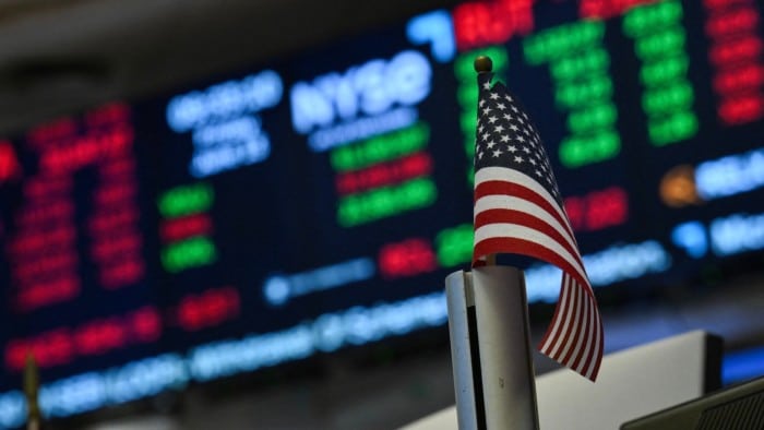A US flag in front of screens at the New York Stock Exchange