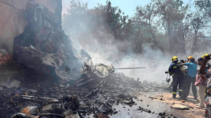 Firefighters battle to extinguish burning wreckage at the site of the plane crash in Ahmedabad on Thursday