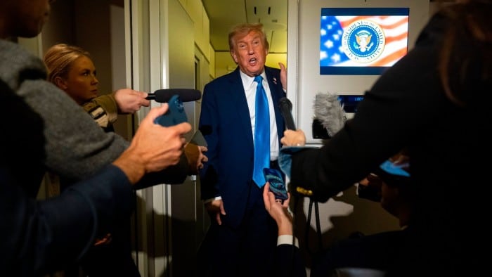 President Donald Trump speaks to reporters while flying aboard Air Force One