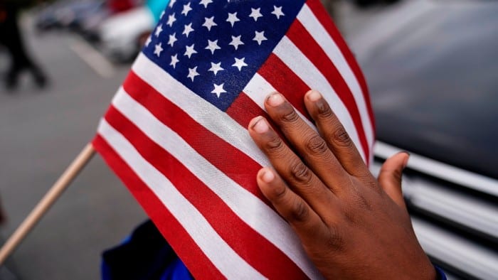 A young child holds an American flag during a campaign