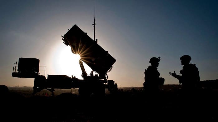 Silhouette of Patriot missile battery and soldiers at sunset