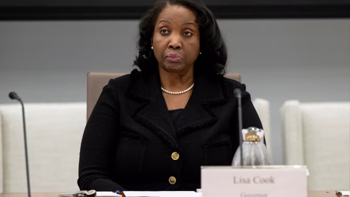 Lisa Cook sits at a table during a Federal Reserve Board meeting.